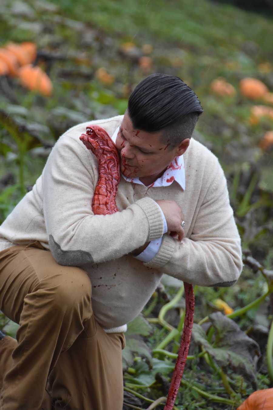 Husband holds bloody creature that came out of his wife's stomach in pumpkin pouch