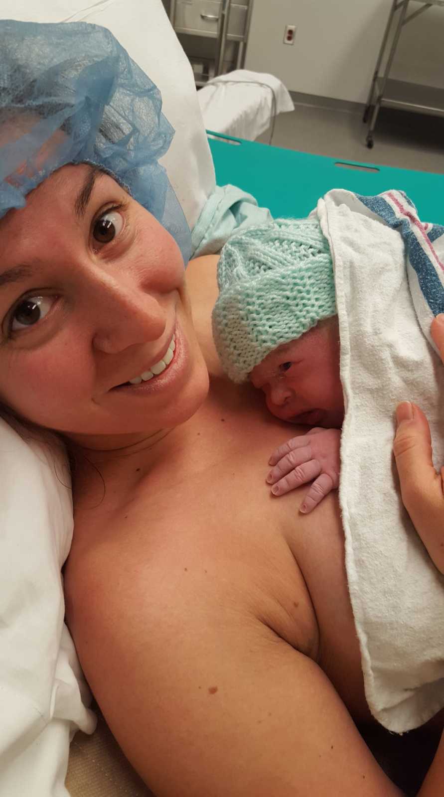 Woman who just gave birth laying with newborn on her bare chest