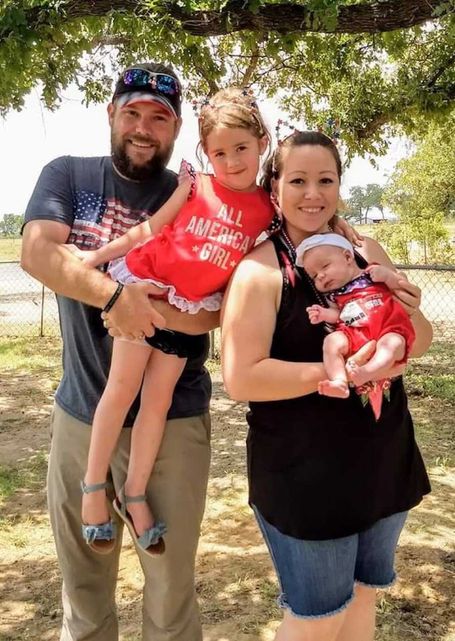 Mother holds baby who keeps her up all night beside husband who holds their older daughter