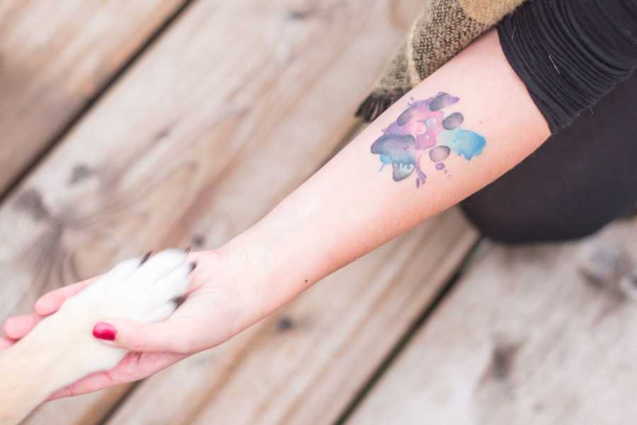 Aerial view of woman holding adopted dog's paw