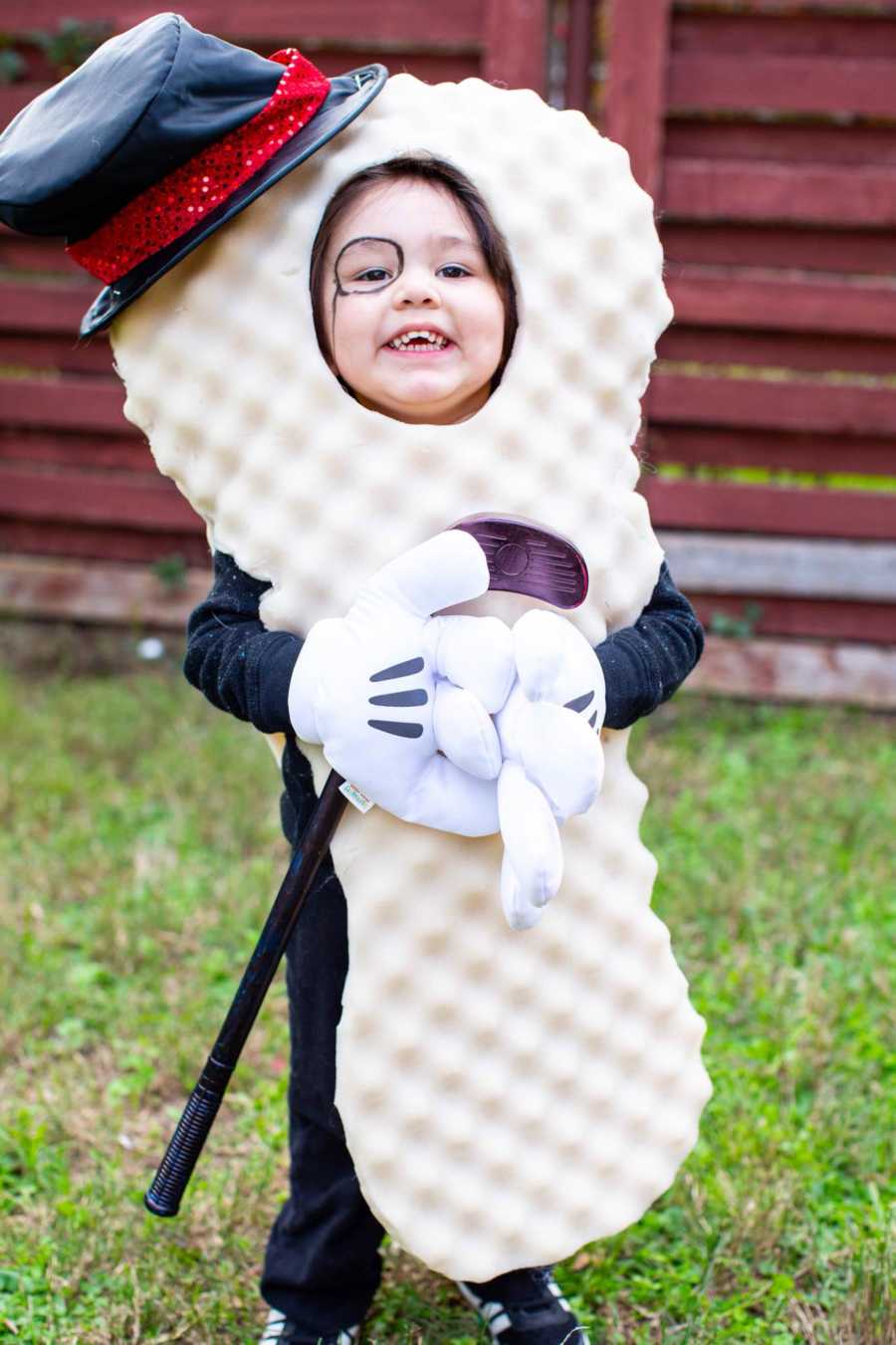 Toddler stands outside smiling in Mr. Peanut costume