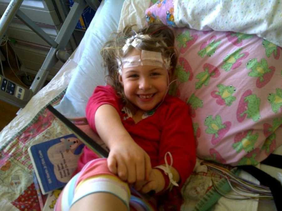 Young girl with absence and petit mal seizures smiles in hospital bed 