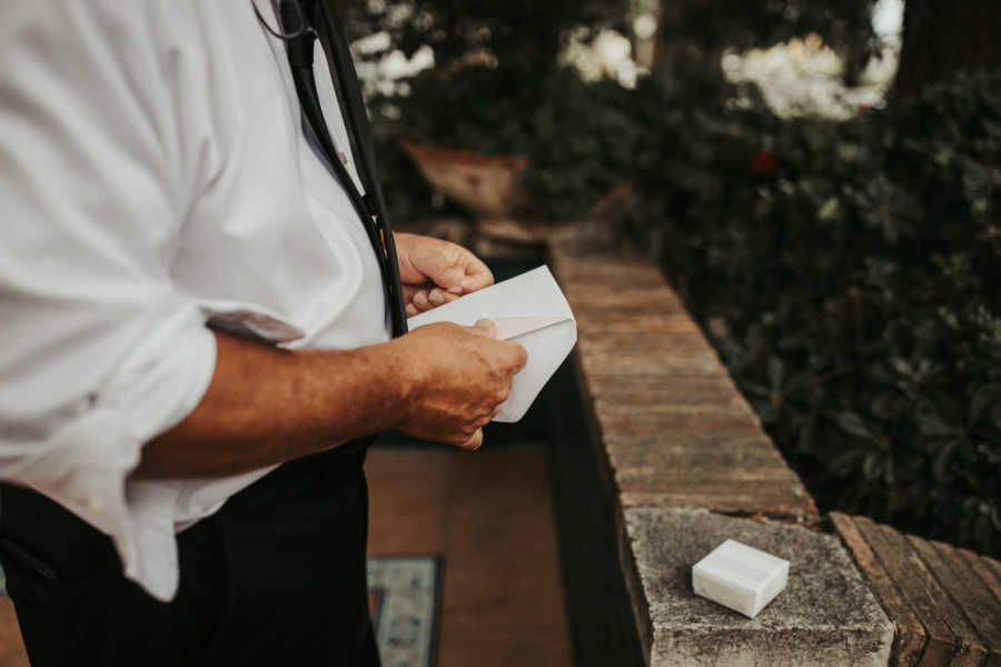 Close up of father opening letter his daughter wrote to him on her wedding day