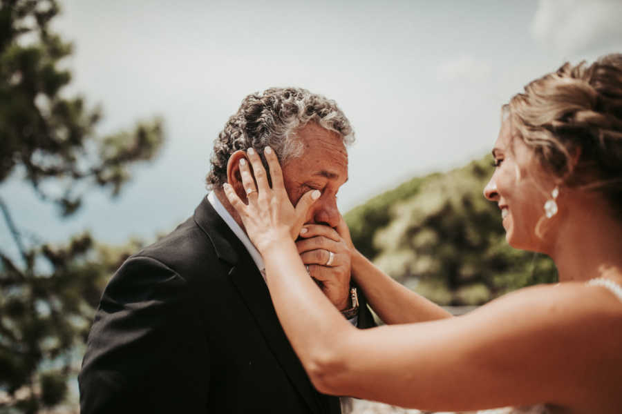Bride wipes away tears on father's face