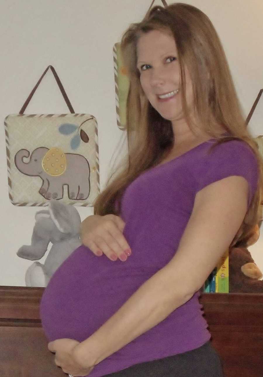 Pregnant woman smiles in nursery