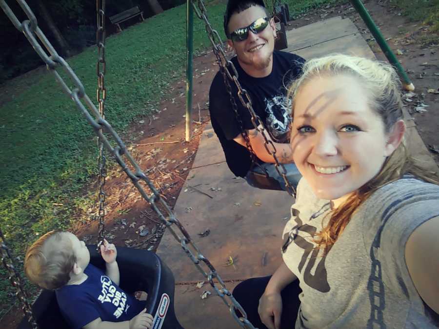 Parents who got clean for their son smile in selfie with their son on swing set