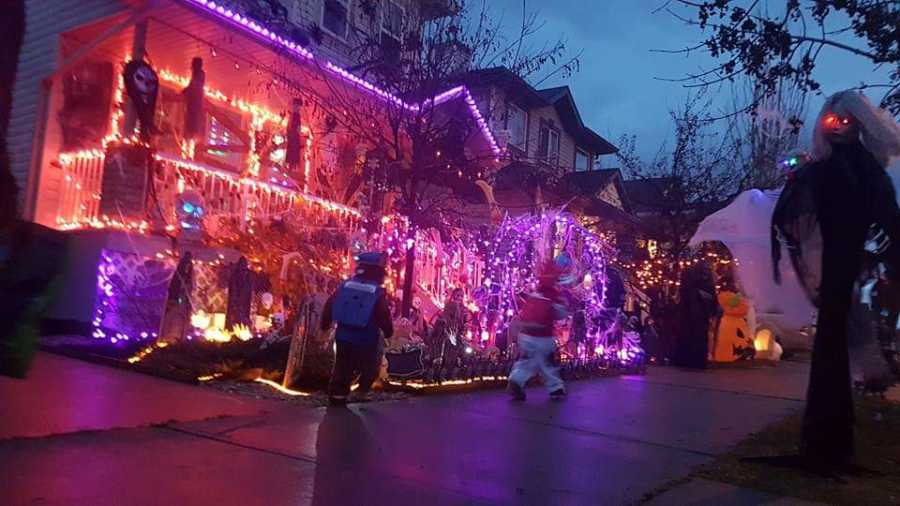 House covered in Halloween decorations and Halloween colored lights