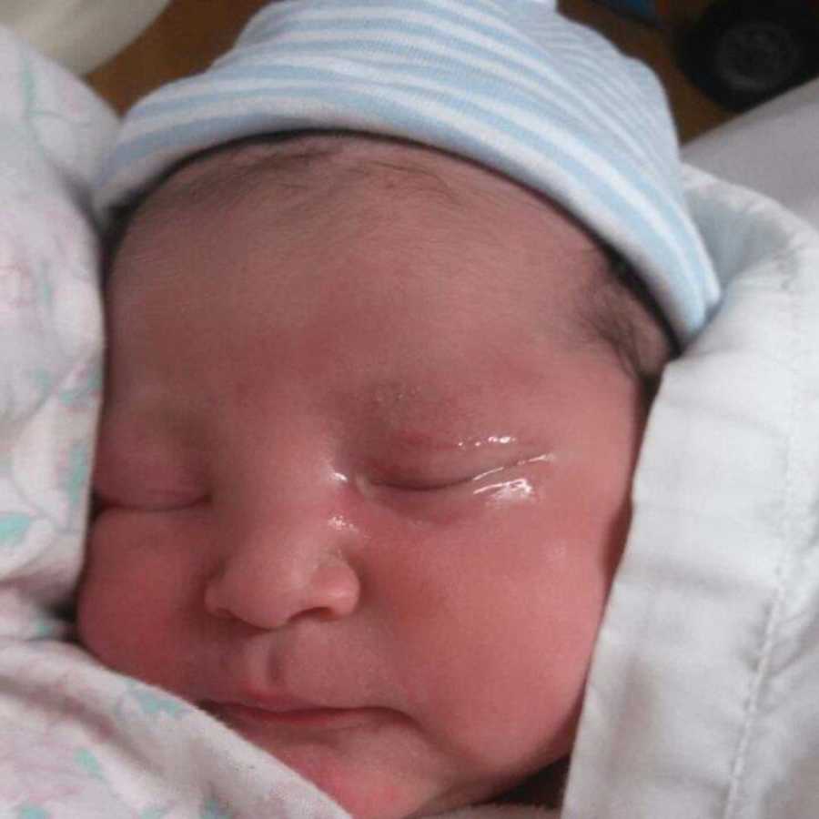 Close up of newborn boy's face who was born without a right arm