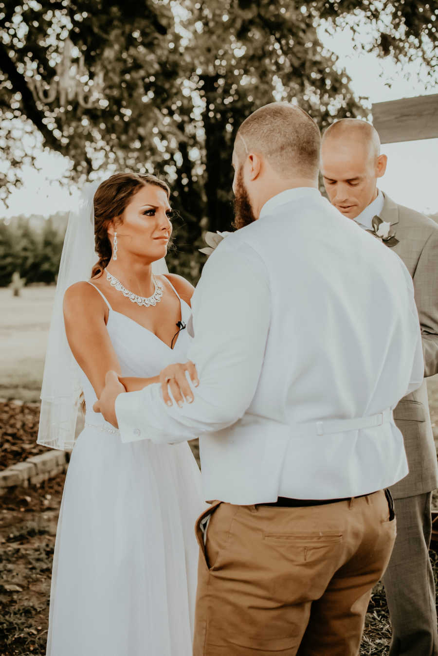 Paralyzed bride cries as she holds on to man's arms