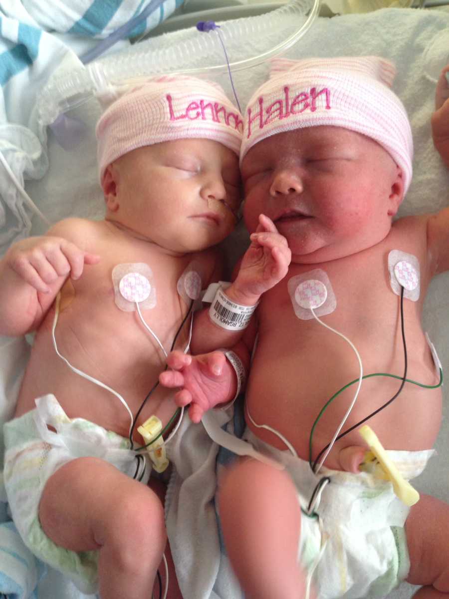 Twin newborns lying asleep in NICU