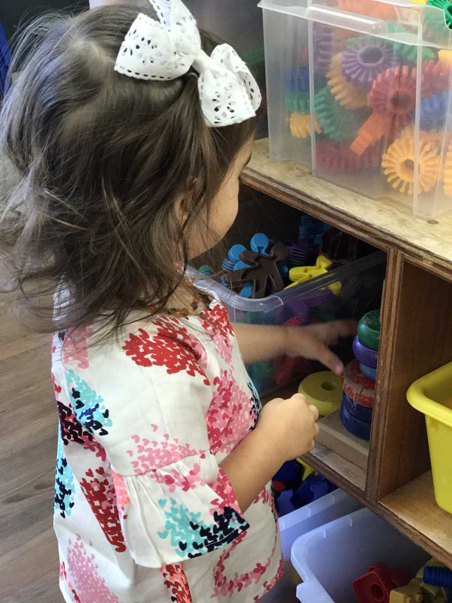 Little girl playing with toys in classroom whose mother had a hard time letting her go