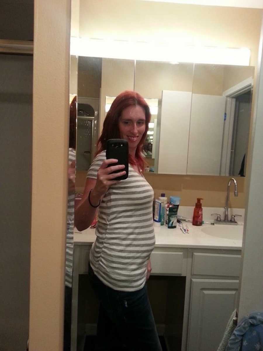 Pregnant woman whose baby died in her stomach smiles in mirror selfie in bathroom