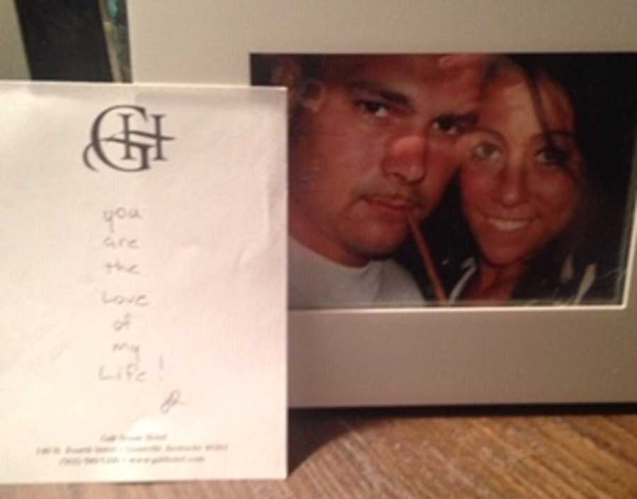 Picture frame of husband and wife with note beside it that says, "you are the love of my life" written by husband
