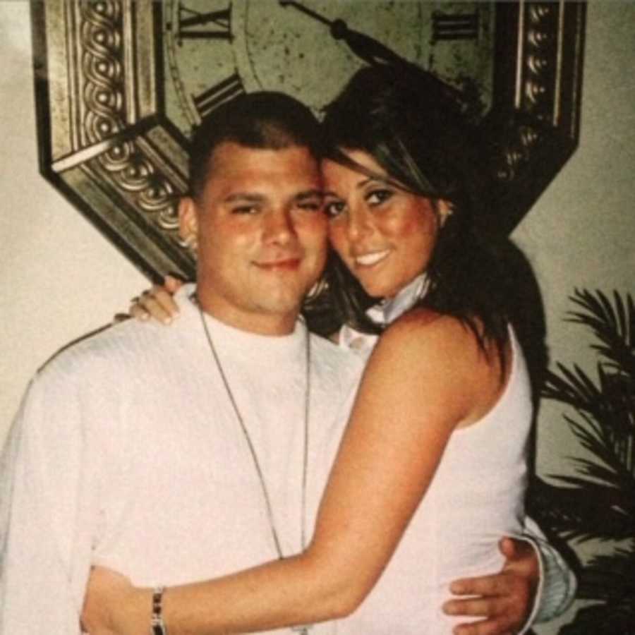 Young boyfriend and girlfriend stand hugging and smiling