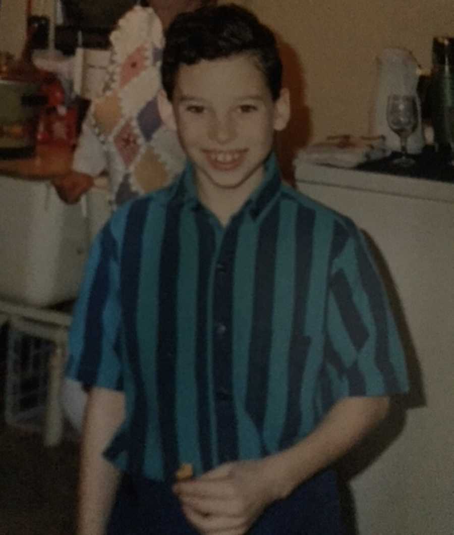 Young boy who will later in life die from smoking a heroin-laced joint smile in blue and teal striped shirt