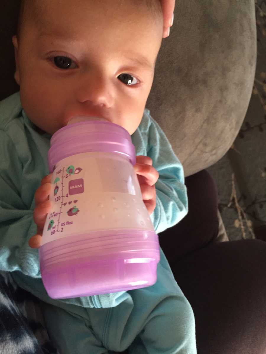 Young baby drinking out of bottle