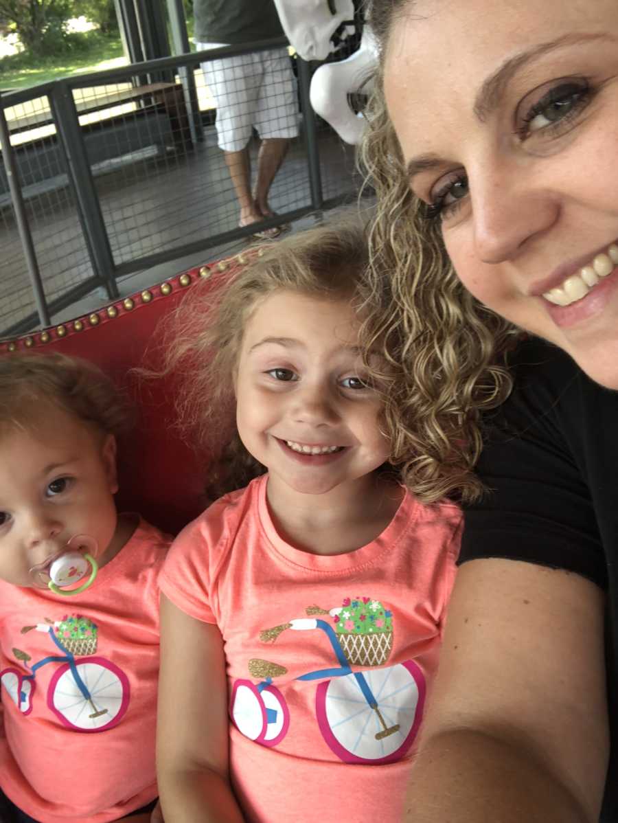 Woman smiles in selfie with autistic daughter and younger daughter