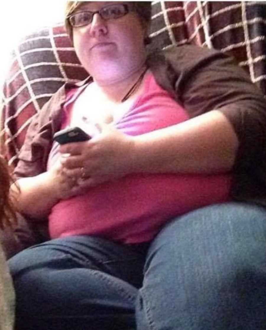 Woman who has gained a lot of weight sits in chair on her iphone
