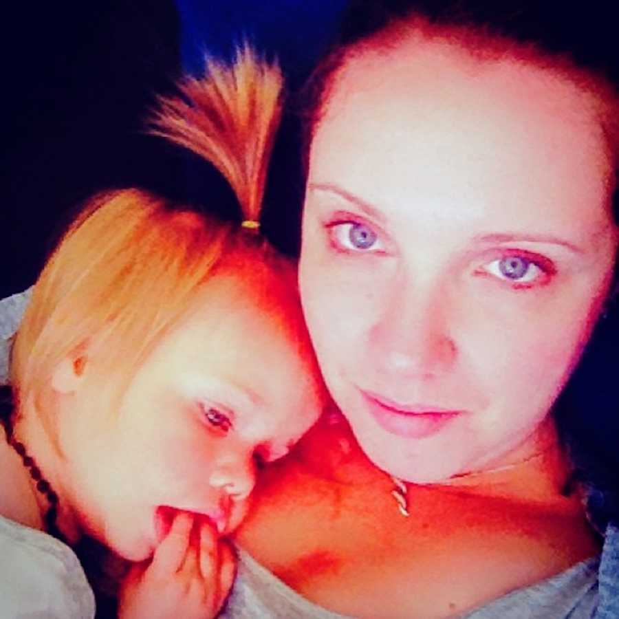 Mother addicted to drugs takes selfie while daughter rests her head on mother's shoulder