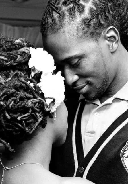 Groom smiles down at his bride smiling as they stand closely