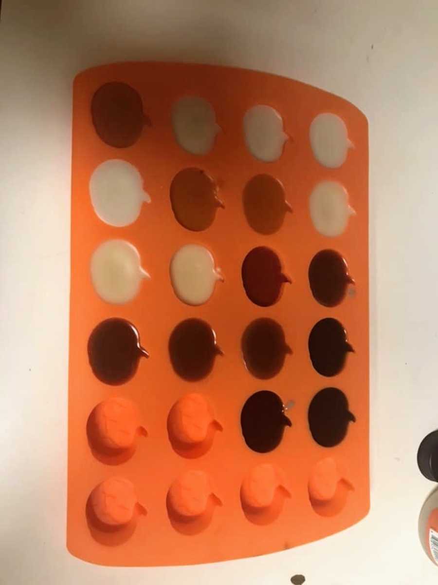 Ice tray in shape of pumpkins filled with melted wax