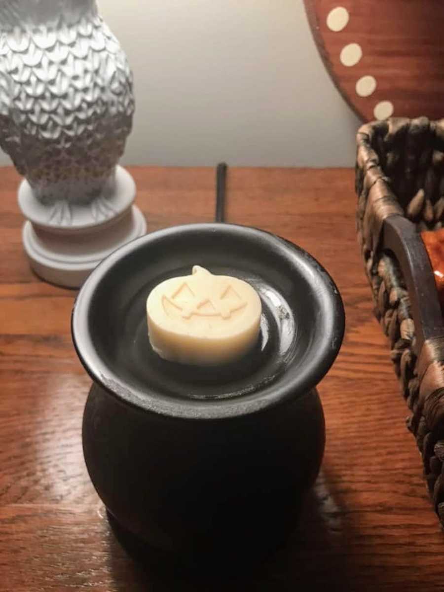 Candle wax in shape of pumpkin sitting on wax melter