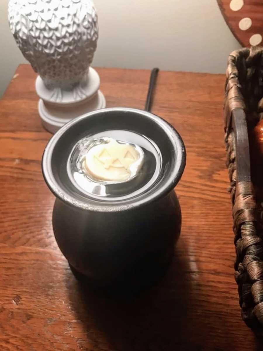 Candle wax in shape of pumpkin melting on wax melter
