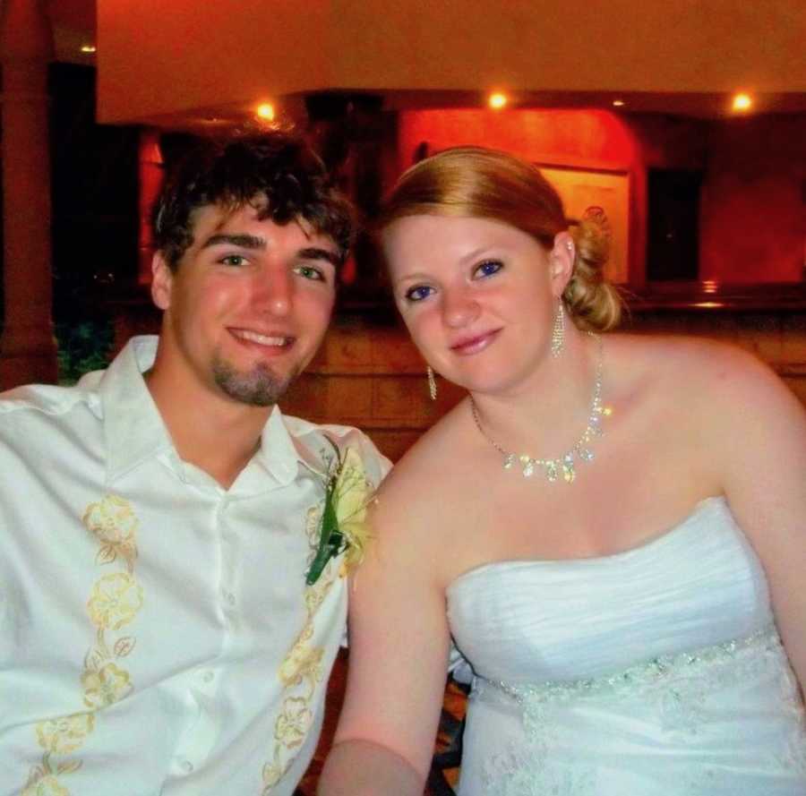 Bride and groom sit beside each other smiling 