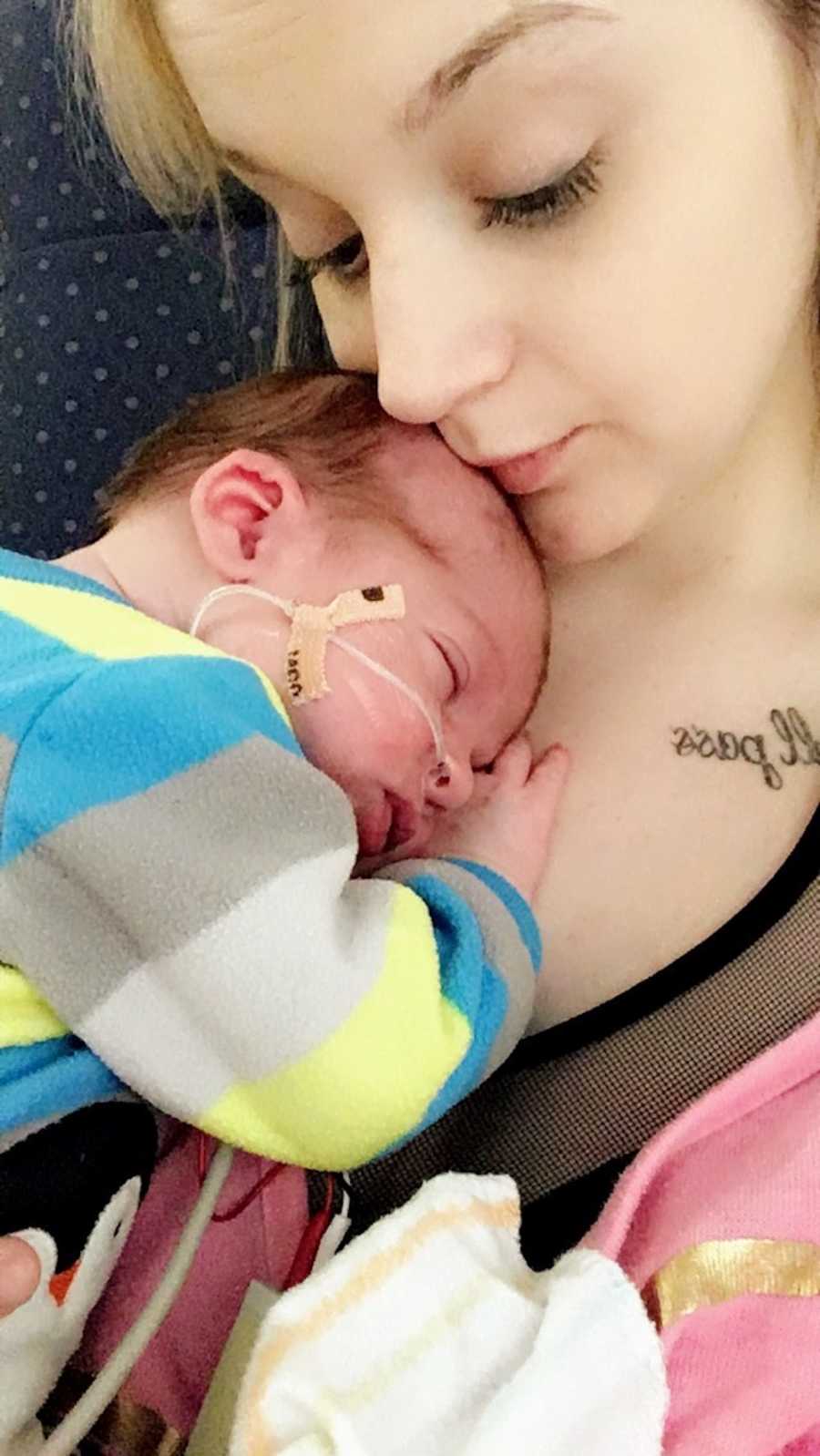 Mother looks down as newborn with Hirschsprung Disease lays asleep on her chest