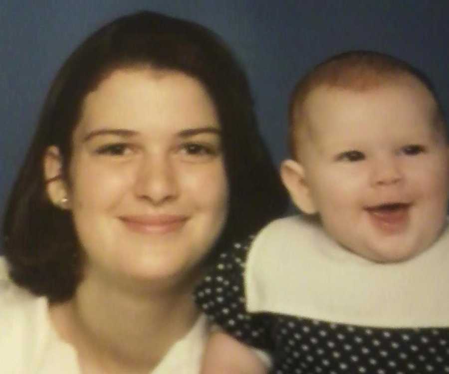 Teen mother smiling beside her baby daughter