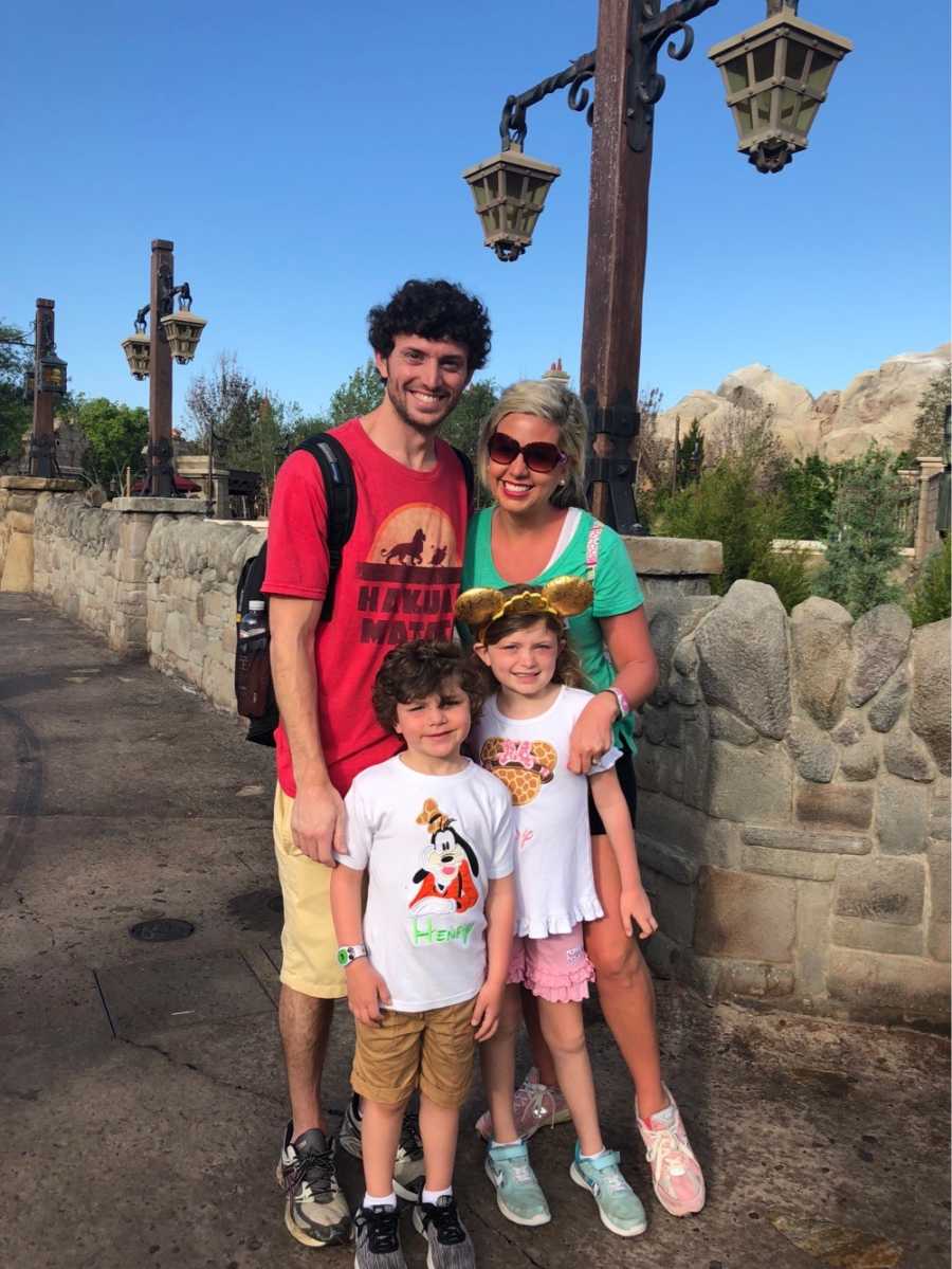 Husband and wife stand with their son and daughter at Disney World
