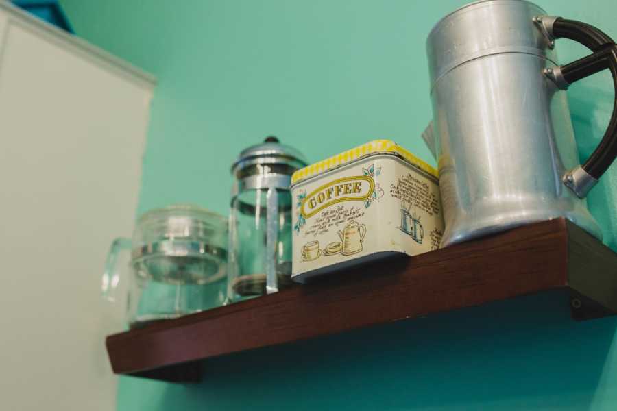 Box of coffee grounds on shelf beside coffee presses