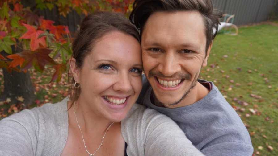 Woman with drug addiction smiles in selfie in backyard with husband