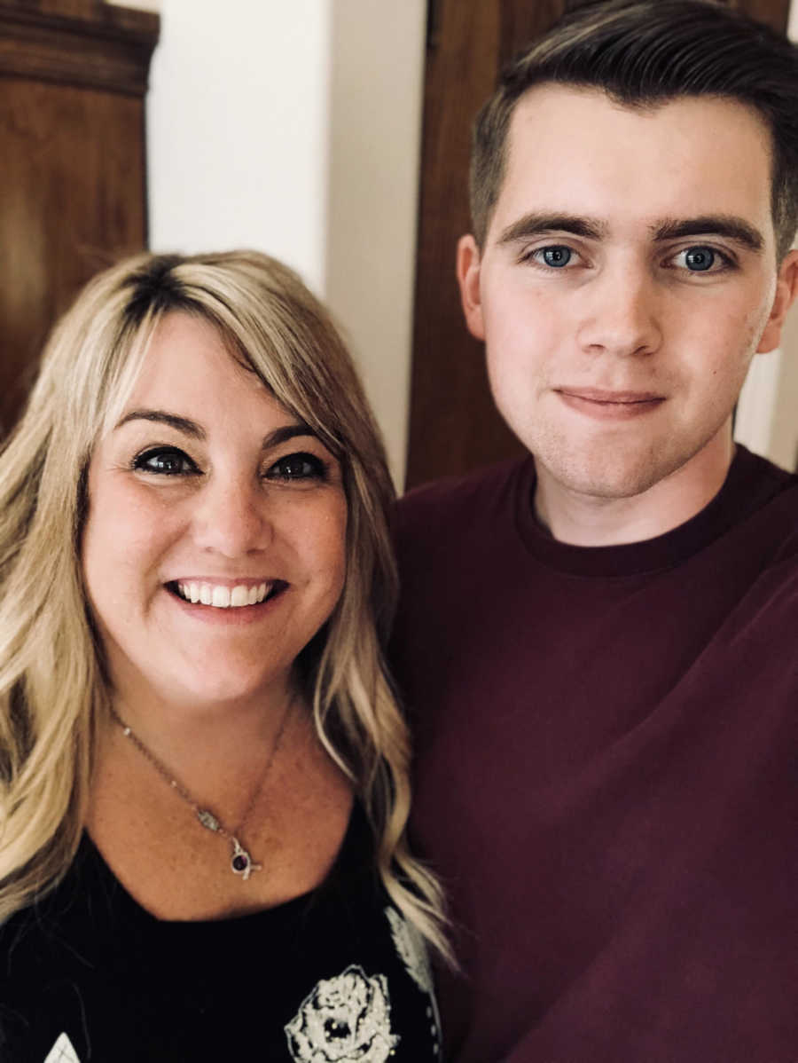 Widow smiles beside her teen son