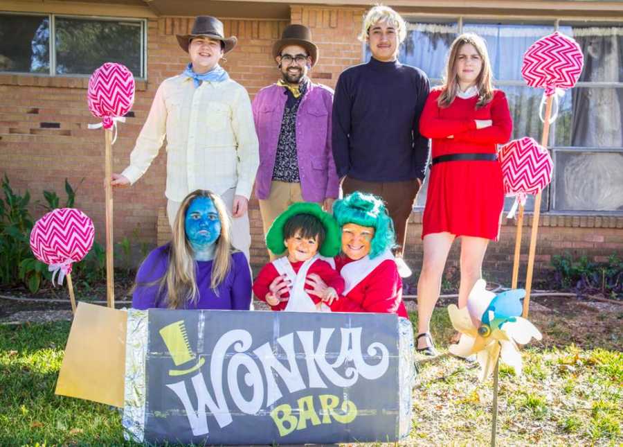 Family stands outside of house dressed as characters from Charlie in the Chocolate Factory