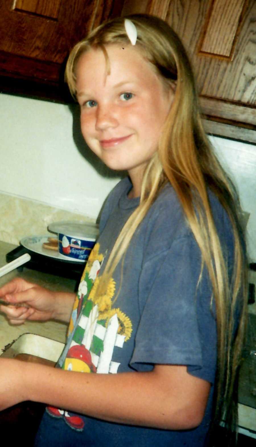 Young girl who is bullied at school smiling in kitchen