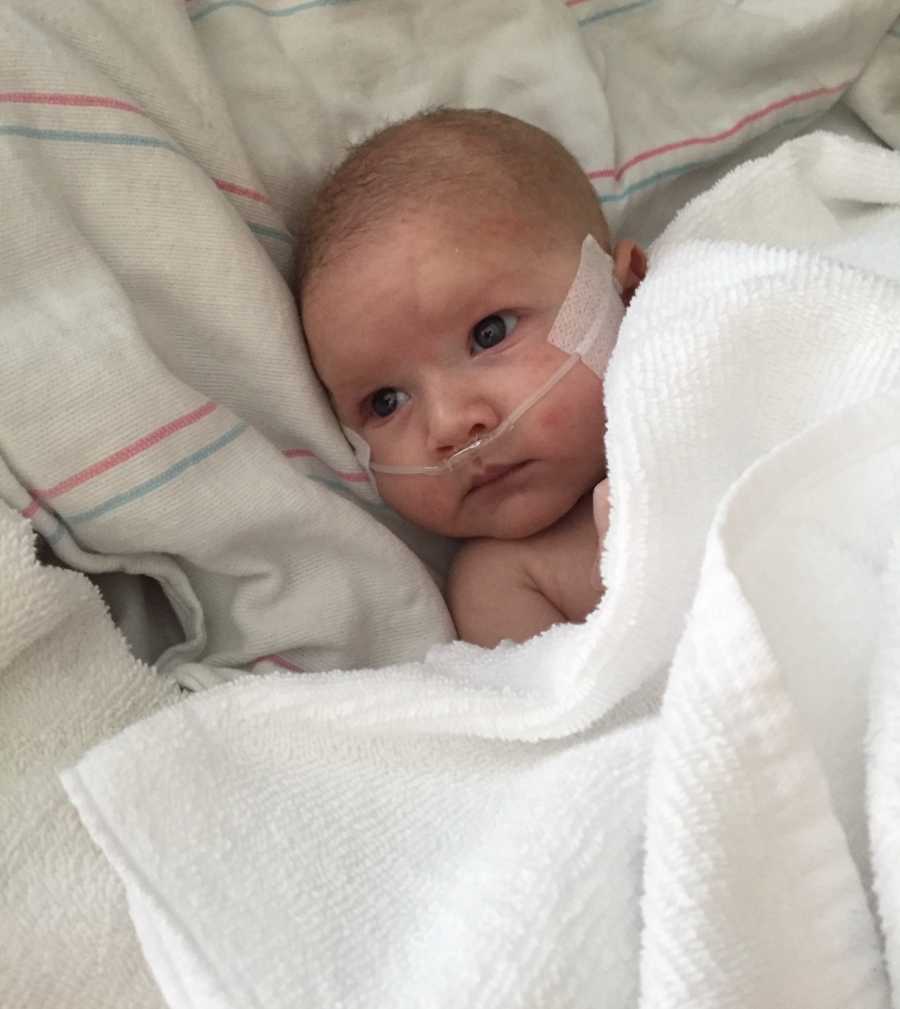 Infant laying in hospital bed with oxygen tube up her nose