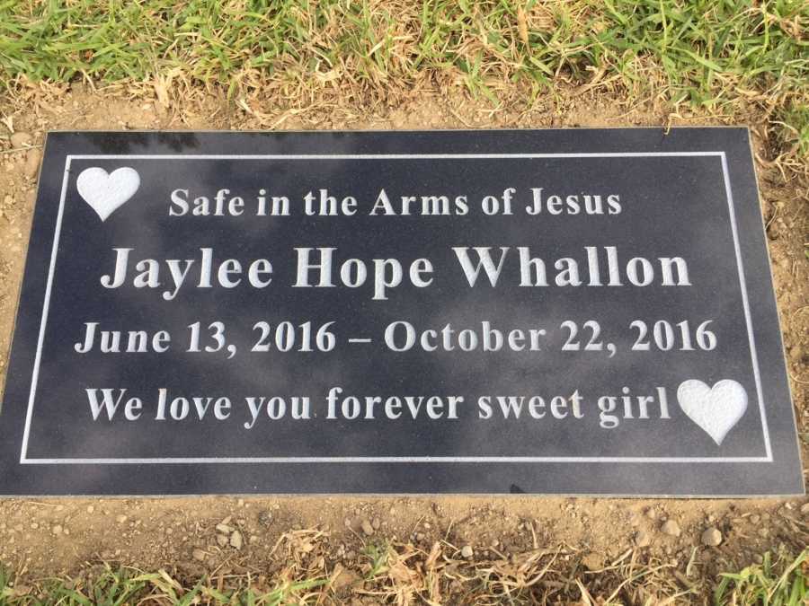 Plaque in ground for deceased infant that says, "Safe in the Arms of Jesus"