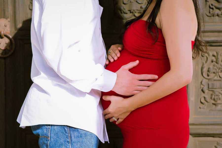 Close up of pregnant woman and husband holding her stomach