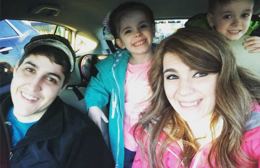 Mothers smile in selfie in car with their two foster kids in back seat