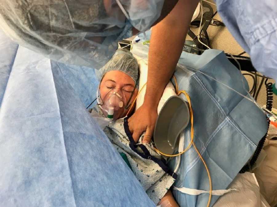 Pregnant woman with HELLP laying in operating room with oxygen mask on