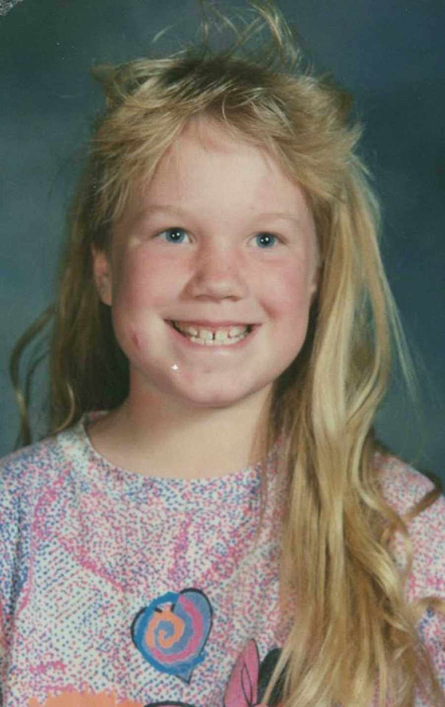 Little girl smiling for school picture with red bump on her cheek