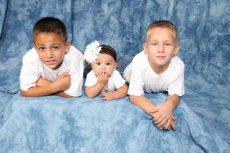 Children of woman who lost her brother in car accident lying down on blue backdrop for photoshoot