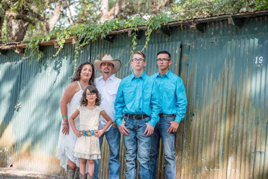 Husband and wife who just renewed their vows stand with their three children
