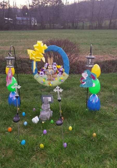 Angel statue outside for miscarried boy with Easter decorations around it