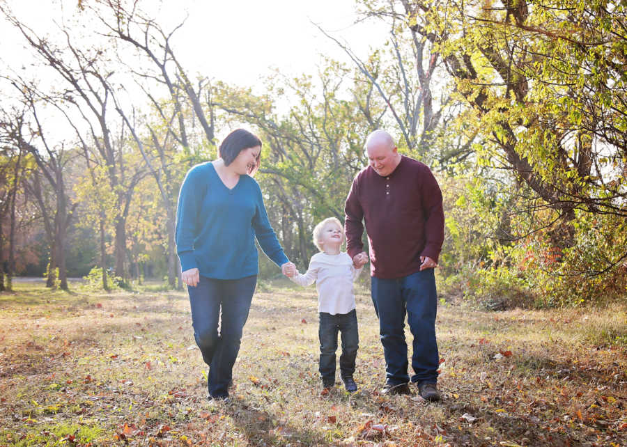 Mother and father walk holding toddlers hand who was in NICU for long time as a baby