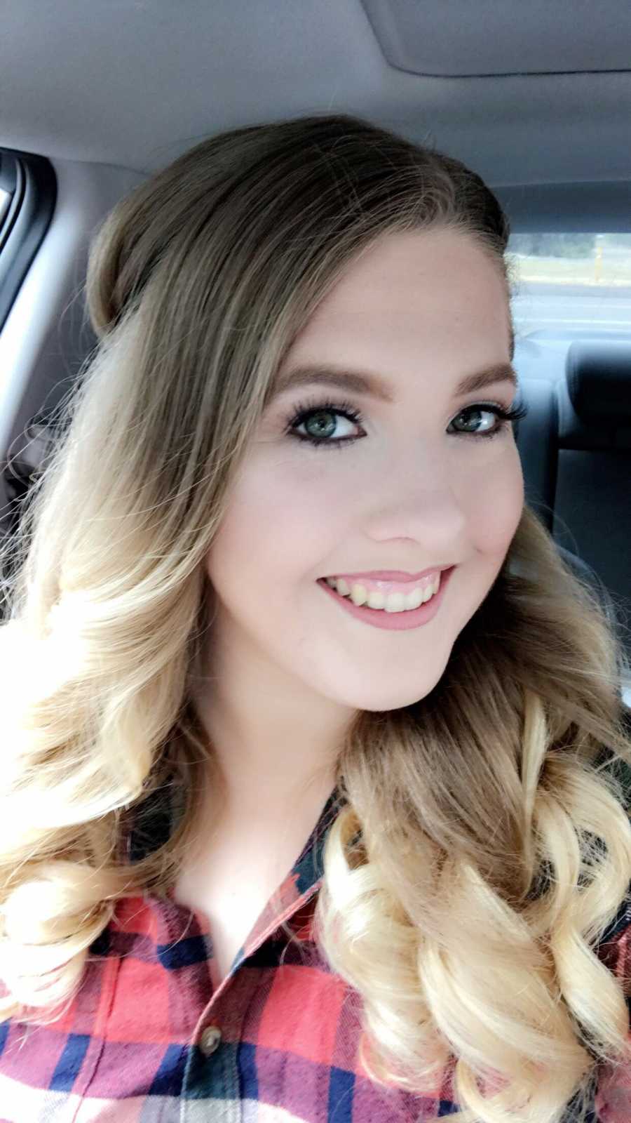 Woman with sever anxiety smiles in selfie in her car