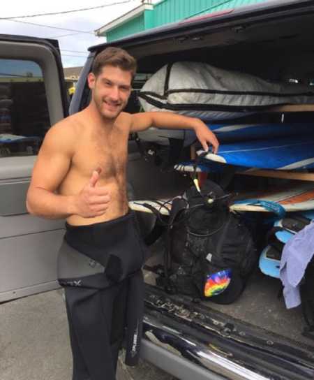 Recovered alcoholic stands beside open trunk filled with surfboards 