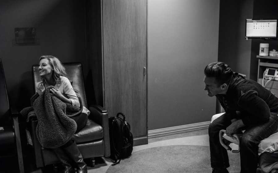 Husband and wife sitting in hospital room waiting to meet their adopted newborn