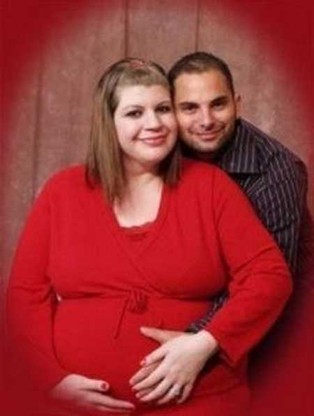 Pregnant woman with Hyperemesis gravidarum smiles beside husband while they both hold her stomach